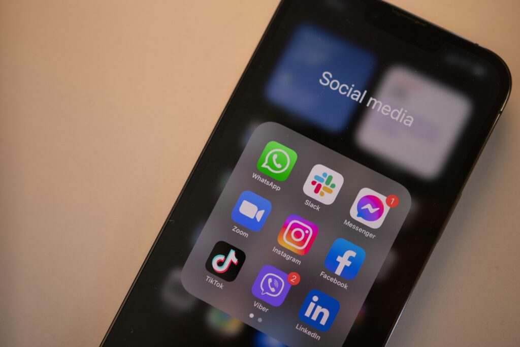 The image shows a close-up of a smartphone screen displaying a folder labeled "Social media". Inside the folder are several popular social and communication apps